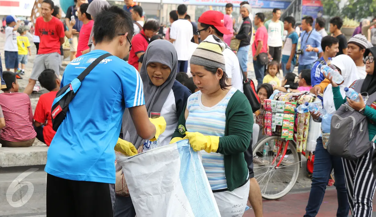 Relawan saat mengajak warga untuk ikut memungut sampah selama Clean Up Jakarta Day di Bunderan Hotel Indonesia, Jakarta, minggu (18/10/2015). Kegiatan Clean Up Jakarta Day (CUJD) 2015 akan membersihkan Jakarta di 30 titik. (LIputan6.com/Herman Zakharia)
