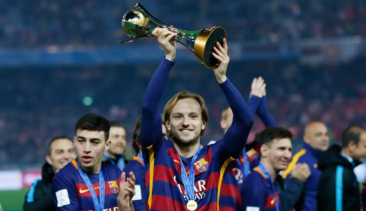 Pemain Barcelona, Ivan Rakitic mengangkat trofi Piala Dunia Antarklub 2015 usai menundukkan River Plate 3-0, dalam pertandingan di Stadion Internasional Yokohama, Jepang, Minggu (20/12). Barca menaklukan River Plate 3-0. (Reuters/Thomas PeterLivepic)