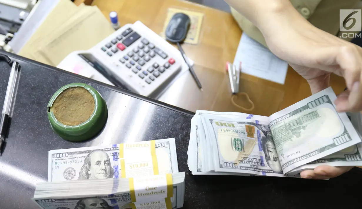 Pekerja menghitung mata uang Dolar AS di jasa penukaran uang asing di Jakarta, Rabu (19/6/2019). Nilai tukar rupiah terhadap Dolar AS sore ini Rabu (19/6) ditutup menguat sebesar Rp 14.269 per dolar AS atau menguat 56,0 poin (0,39 persen) dari penutupan sebelumnya. (Liputan6.com/Angga Yuniar)