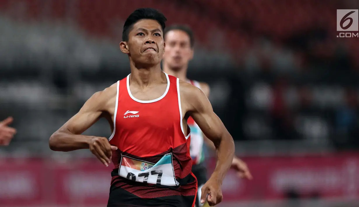 Atlet para-atletik Indonesia, Sapto Yogo Purnomo usai laga lari nomor 100 meter T37 pria yang  digelar di Stadion GBK, Jakarta, Selasa (9/10). Ini menjadi medali emas kedua Sapto di Asian Para Games 2018. (Liputan6.com/Helmi Fithriansyah)