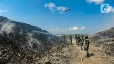 Anggota Raider 900/SBW TNI AD dan helikopter Badan Nasional Penanggulangan Bencana (BNPB) berupaya untuk memadamkan kebakaran sampah di Tempat Pembuangan Akhir (TPA) Regional Sarbagita Suwung, Denpasar, Bali, Jumat (20/10/2023). Hingga saat ini, kebakaran yang terjadi pada Kamis (12/10) tersebut belum dapat dipadamkan. (merdeka.com/Arie Basuki)
