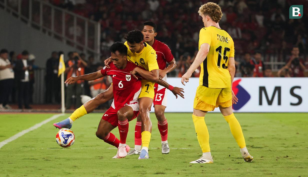 Pemain Timnas Indonesia U-23, Robi Darwis (kiri) berebut bola dengan pemain Malaysia, Muhammad Hakimi dalam laga Grup A Piala AFF U-23 2025 di Stadion Utama Gelora Bung Karno (SUGBK), Senayan, Jakarta, Senin (21/07/2025). (Bola.com/Abdul Aziz)