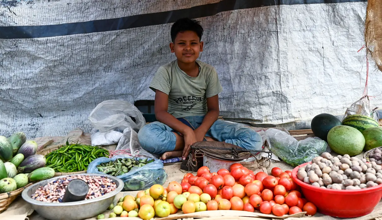 Seorang anak pengungsi Rohingya menjual sayuran di kamp pengungsi Jamtoli di Ukhia (22/3/2022). Ratusan ribu orang Rohingya melarikan diri dari Myanmar setelah tindakan keras tahun 2017, yang menjadi subjek kasus genosida di pengadilan tertinggi PBB di Den Haag. (AFP/Munir Uz Zaman)