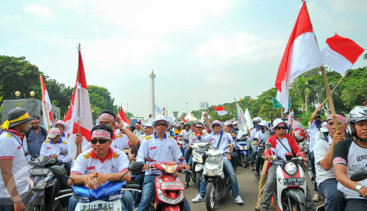 Massa dari Pergerakan Pelaut Indonesia (PPI) membawa atribut bendera ketika berunjuk rasa di Jalan Merdeka Barat, Jakarta, Kamis (12/5). Massa menuntut pemerintah memperhatikan kesejahteraan dan peningkatan upah mereka. (Liputan6.com/Yoppy Renato)