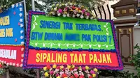 Sejumlah karangan bunga yang berjajar di depan Mapolres Metro Jakarta Selatan, Sabtu (25/2/2023) yang meminta agar pacar Mario Dandy, AG, juga diperiksa. (Merdeka.com/Nur Habibie)