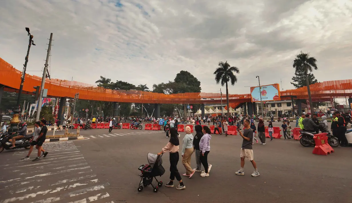 Warga beraktivitas di sekitar Jembatan Penyeberangan Orang (JPO) di Jalan Tegar Beriman, Cibinong, Kabupaten Bogor, Jawa Barat, Minggu (14/6/2026). (Kapanlagi.com/Budy Santoso)