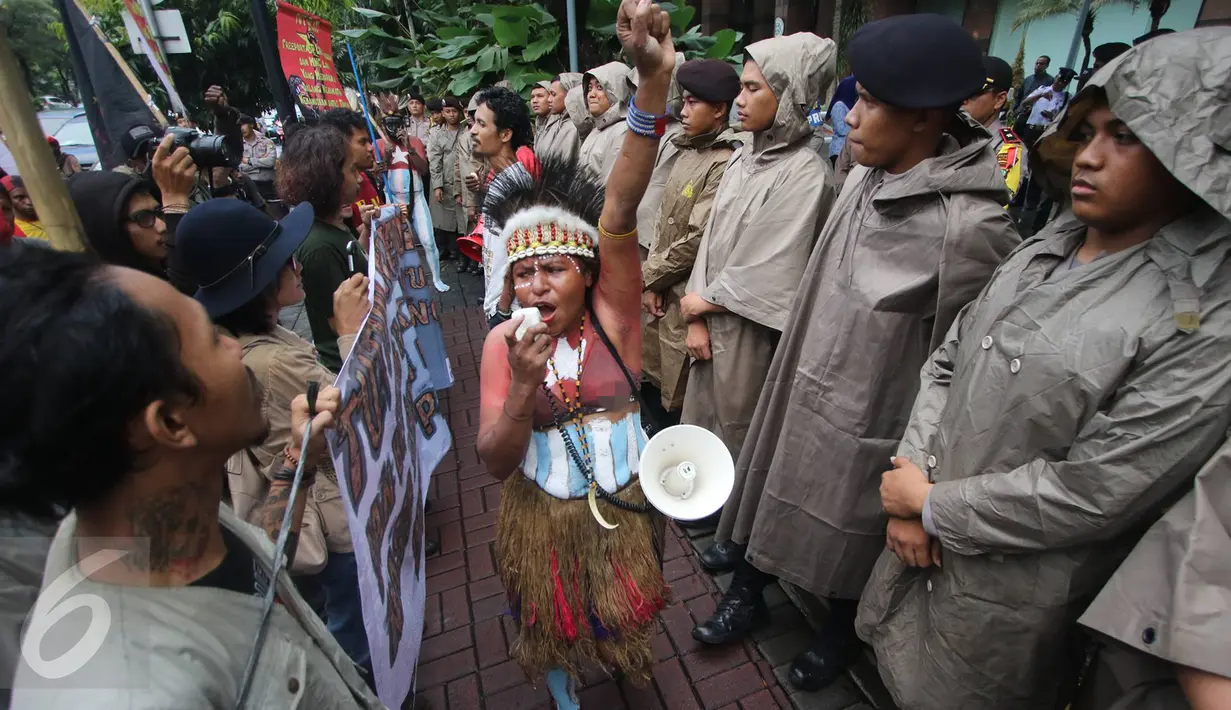 Massa mengenakan kostum tradisional daerah sambil berorasi menyampaikan tuntutan di depan kantor PT Freeport Indonesia, Jakarta, Senin (20/3). Mereka menuntut PT Freeport Indonesia segera menutup tambang emasnya di Papua. (Liputan6.com/Immanuel Antonius)