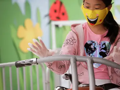 Seorang anak yang mengenakan masker dan sarung tangan menaiki wahana di Playland Amusement Park, di Vancouver, British Columbia, Kanada, pada 10 Juli 2020. Playland Amusement Park dibuka kembali untuk umum pada Jumat (10/7), dengan langkah-langkah protokol kesehatan. (Xihua/Liang Sen)