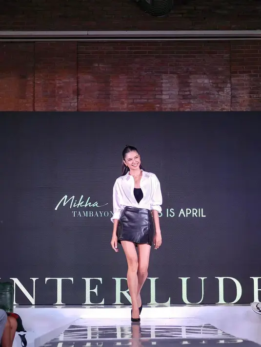 Potret Mikha Tambayong melenggang di runway juga bisa jadi inspirasi. Ia mengenakan inner hitam, dipadu kemeja putih, dan mini skirt hitam, serta heels hitam. [Foto: Instagram/miktambayong]