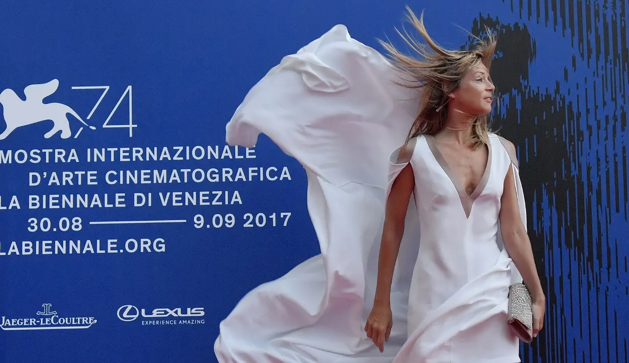 Ekspresi Gaia Trussardi ketika gaun yang dikenakannya tertiup angin saat menghadiri "Penghargaan Franca Sozzani" selama Festival Film Venice ke-74 di Venice Lido (1/9). (AFP Photo/Tizianaa Fabi)