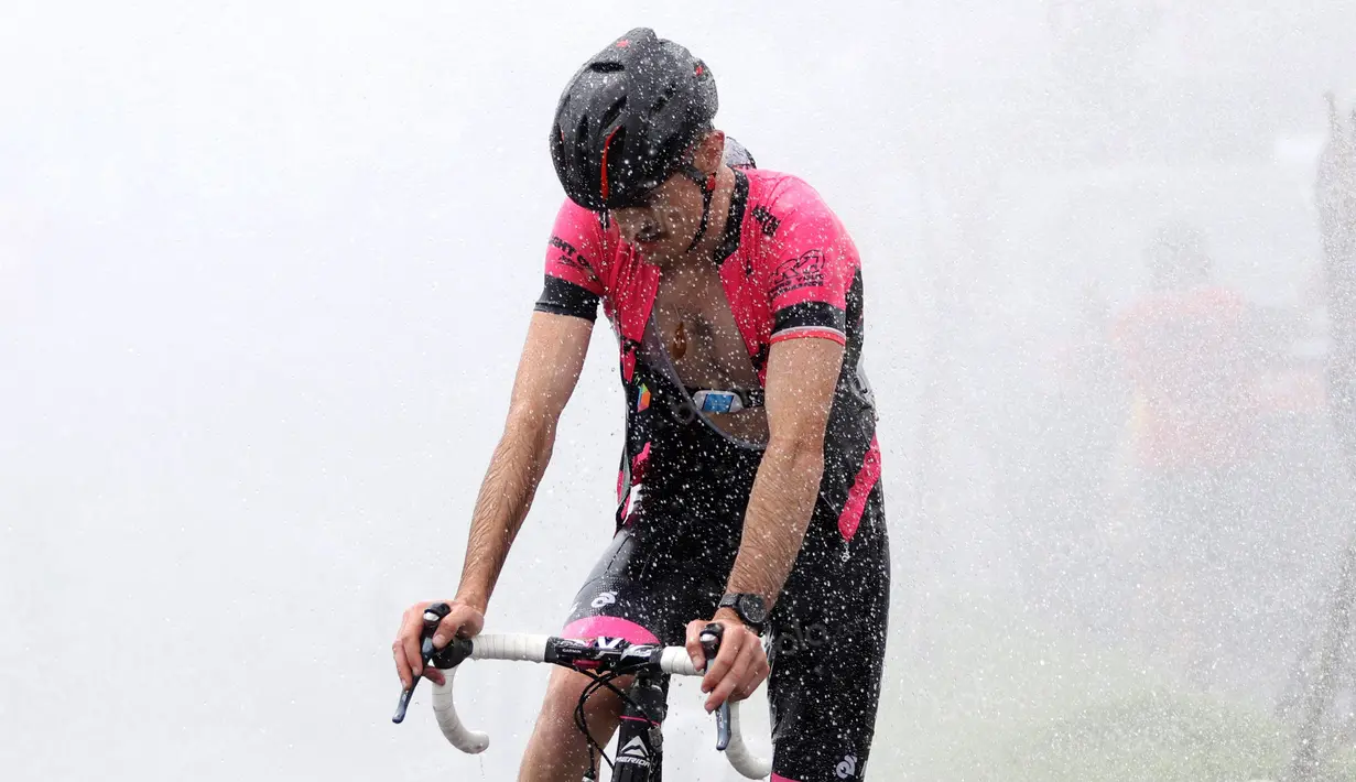 Pebalap mendinginkan suhu badan dengan air semprotan pemadam kebakaran usai etape ke-8 Tour de Singkarak 2016 di Kota Padang, Sumatera Barat, Minggu (14/8/2016). (Bola.com/Nicklas Hanoatubun)