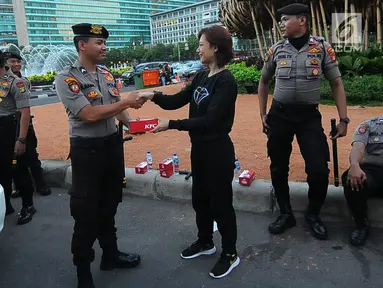 Relawan TKN Jokowi-Ma'ruf Amin membagikan makanan berbuka puasa kepada aparat kepolisian yang melakukan penjagaan di kawasan Bundaran HI, Jakarta, Jumat (24/5/2019). Kegiatan ini sebagai bentuk kepedulian untuk aparat yang telah menjaga keamanan di Jakarta. (Liputan6.com/Angga Yuniar)