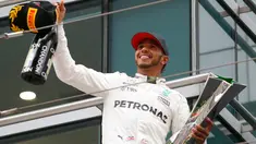 Pembalap Mercedes, Lewis Hamilton bersorak sambil memegang trofi Grand Prix (GP) China di Sirkuit Internasional Shanghai, Minggu (9/4). Hamilton finis pertama dengan catatan waktu 1 jam 37 menit 36,158 detik.(AP Photo/Toru Takahashi)