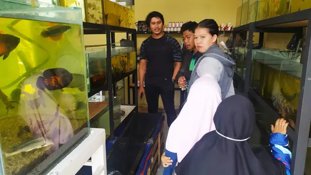 Nampak Mansyahlan, tengah melayani beberapa pengunjung yang datang ke kios ikan hiasnya yang berada di bilangan jalan  Karangpawitan, Garut, Jawa Barat.