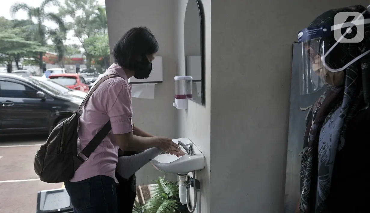 Pengunjung mencuci tangan sebelum memasuki Kantor Imigrasi Kelas I TPI Jakarta Timur, Senin (15/6/2020). Direktorat Jenderal Imigrasi kembali membuka layanan kantor imigrasi di seluruh Indonesia usai memberlakukan pembatasan pelayanan sejak 24 Maret 2020 akibat Covid-19 (merdeka.com/Iqbal S Nugroho)