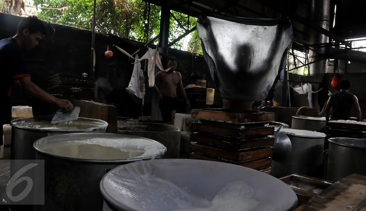 Sejumlah perajin memproduksi tahu industri rumahan di Jakarta, Selasa (10/11). Menurunnya daya beli masyarakat menyebabkan sejumlah rumah produksi tahu menurunkan produksinya dari 100 kg per hari menjadi 70 kg per hari. (Liputan6.com/Johan Tallo)