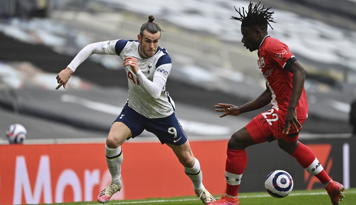 Penyerang Tottenham Hotspur, Gareth Bale, berusaha melewati pemain Southampton, Mohammed Salisu, pada laga Liga Inggris di London, Rabu (21/4/2021). Tottenham menang dengan skor 2-1. (Justin Setterfield/Pool via AP)