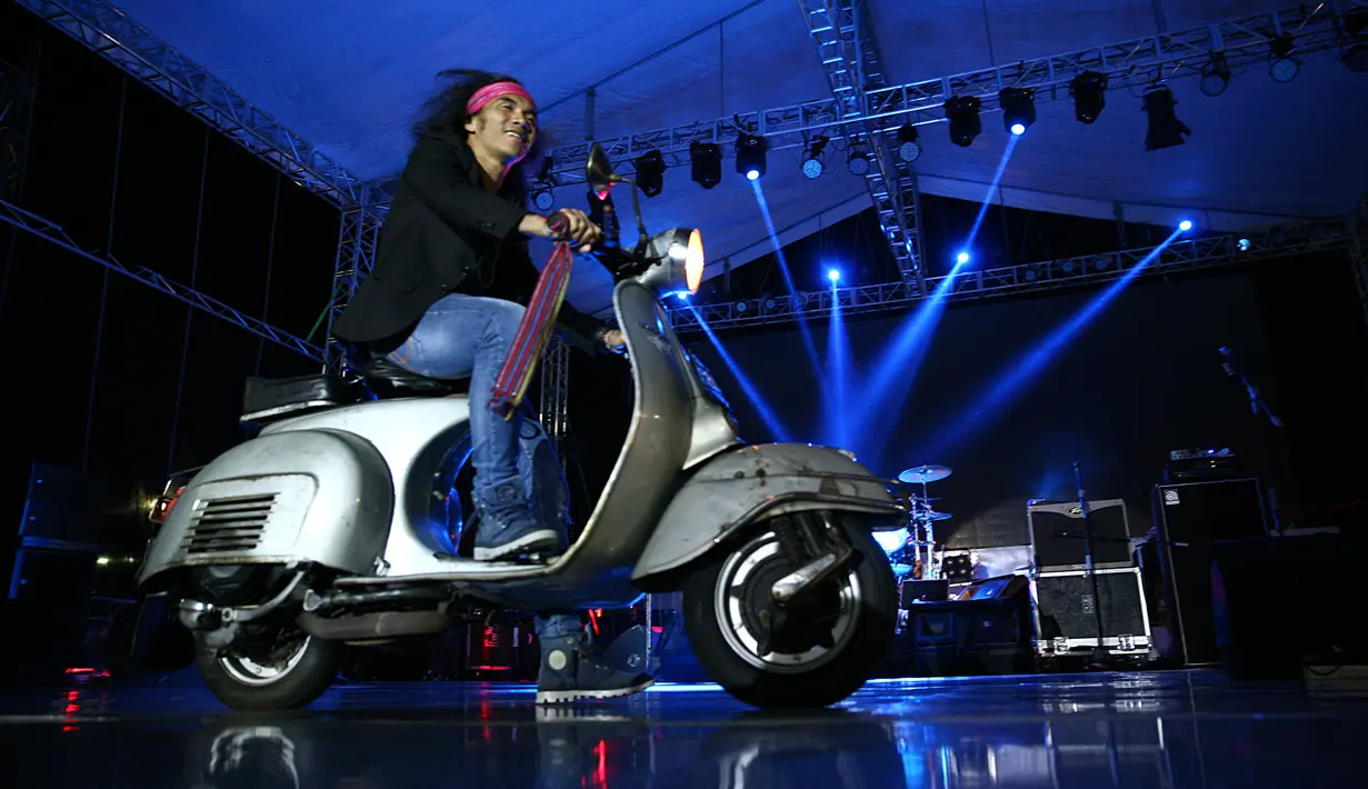 Vokalis Slank, mengawali penampilannya dengan berbeda. Kaka muncul di panggung dengan mengendarai motor vespa. Slank memulai konsernya yang bertajuk Rock n Roll. (Nurwahyunan/Bintang.com)