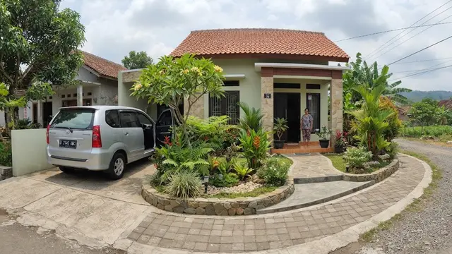 Desain rumah sederhana dengan taman tapi tetap punya area parkir model dengan taman kecil di tengah