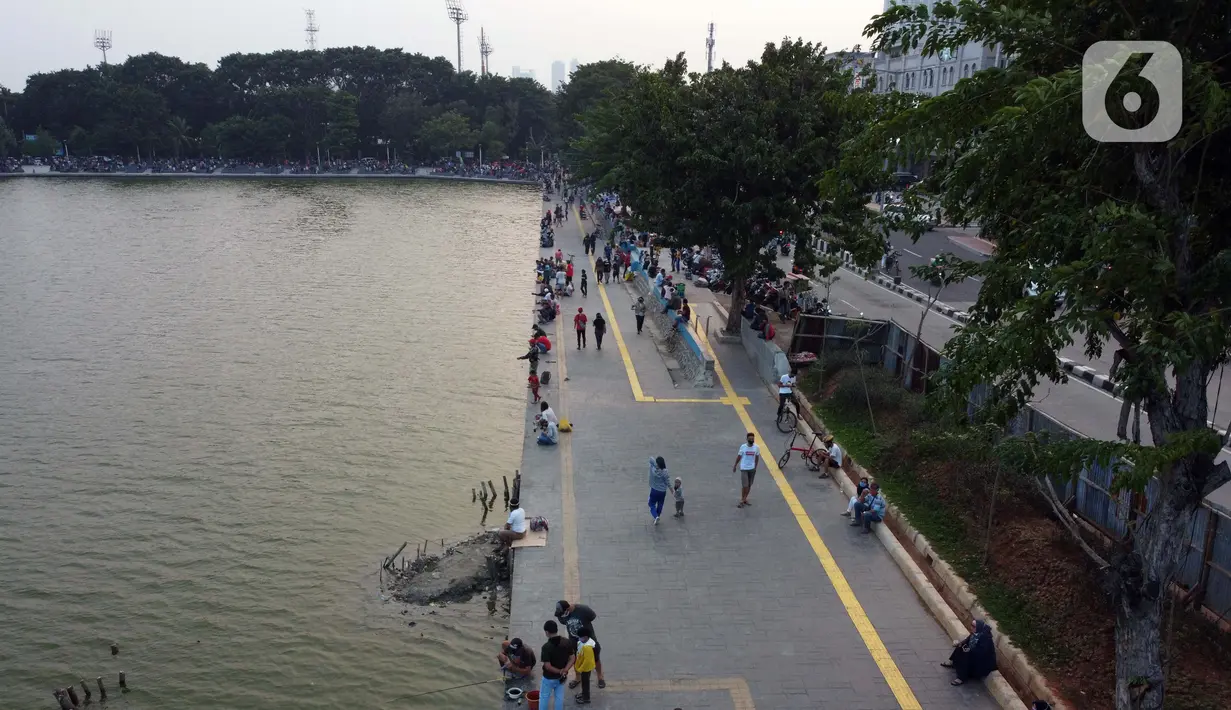 Foto udara memperlihatkan aktivitas warga di pedestrian Danau Sunter, Jakarta, Sabtu (27/6/2020). Beragam aktivitas dilakukan warga sambil menikmati waktu sore di area Danau Sunter, Jakarta. (Liputan6.com/Helmi Fithriansyah)