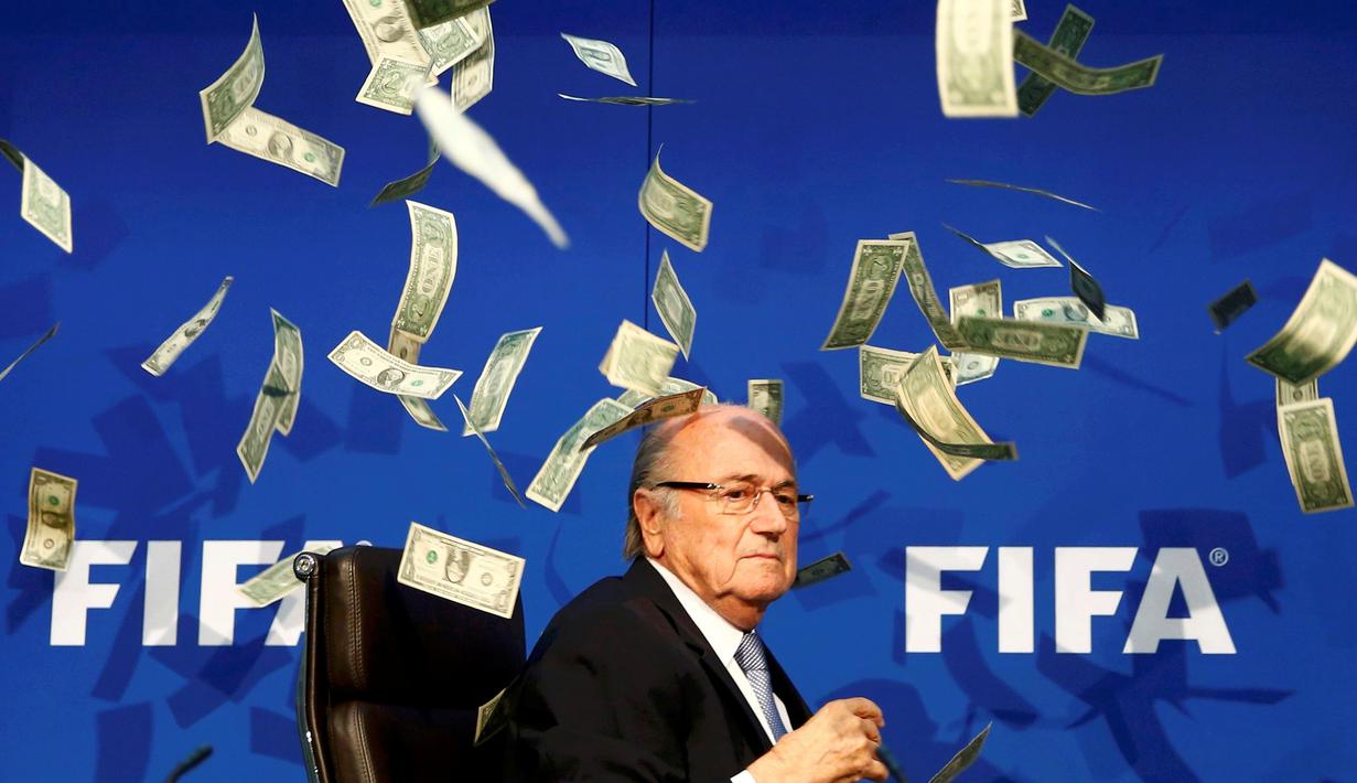 Ekspresi Presiden FIFA, Sepp Blatter, sesaat setelah di lempar segepok uang dollar oleh pelawak Inggris, Simon Brodkin, jelang konferensi pers di kantor FIFA di Zurich, Swiss. (20/7/2015). (REUTERS/Arnd Wiegmann)