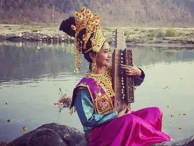 Aktris Ayu Laksmi berpose mengenakan pakaian tradisional sambil memegang alat musik. Selain menjadi pemain film, Ayu merupakan seniman yang terbilang serba bisa, ia bisa bernyanyi, bermain musik, menciptakan lagu, dan teater. (instagram/ayulaksmibali)