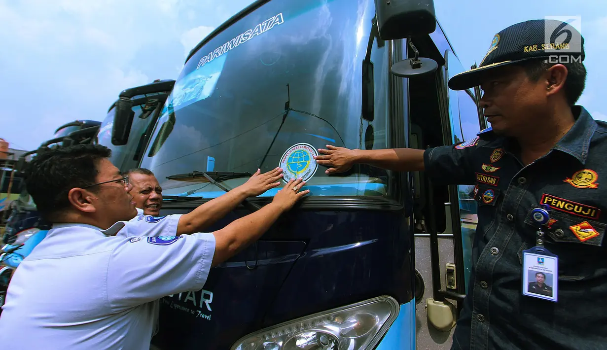 Petugas menempelkan stiker setelah mengecek kondisi bus di Pool Blue Star, Pondok Cabe, Rabu (30/5). Pengecekan ini dilakukan untuk memastikan kelayakan armada bus yang akan digunakan untuk mudik lebaran. (Merdeka.com/Arie Basuki)