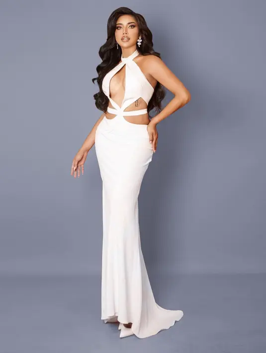 Untuk sesi photoshoot, Millen Cyrus tampil berbeda dengan cut-out dress berwarna putih. Dress ini memiliki detail halter-neck, menampilkan area tengah dadanya yang terbuka. Millen menata rambut panjangnya bergelombang dan dibiarkan tergerai, menariknya ke salah satu sisi. Foto: Instagram.