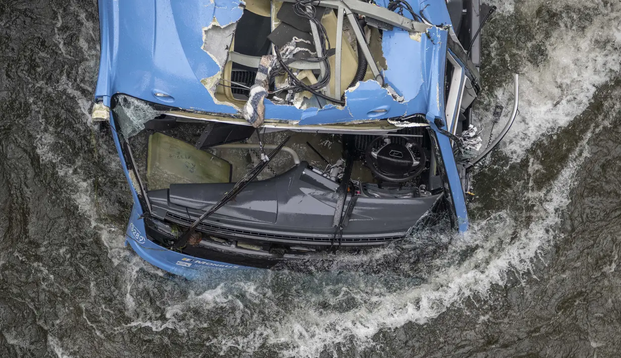 Bangkai bus terlihat di sungai Lerez setelah jatuh saat melintasi jembatan, menewaskan empat orang, di Cerdedo-Cotobade, Spanyol (25/12/2022). Kecelakaan itu terjadi pada 24 Desember malam di dekat Vigo dan perbatasan dengan Portugal. (AFP/Brais Lorenzo)