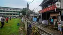 Robohnya tembok menyebabkan satu unit kendaraan roda empat dan dua unit motor rusak. (merdeka.com/Arie Basuki)