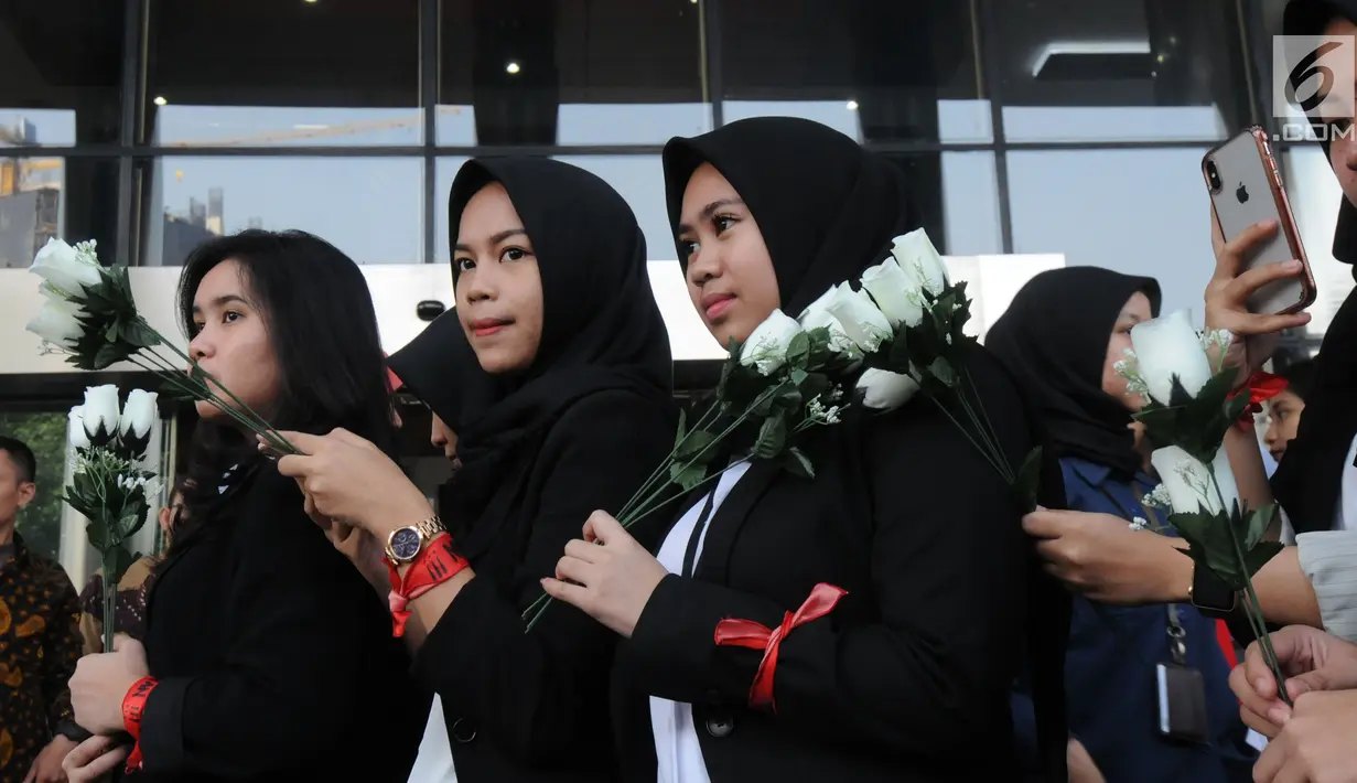 Sejumlah wanita membawa bunga mawar menyambut kedatangan penyidik senior KPK, Novel Baswedan saat masuk kerja kembali di gedung KPK, Jakarta, Jumat (27/7). Novel absen 16 bulan lantaran berobat matanya setelah diserang air keras. (Merdeka.com/Dwi Narwoko)