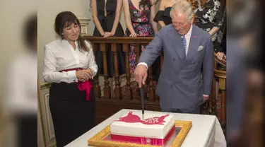 Pangeran Charles bersama pendiri Walk the Walk Nina Barough memotong kue bergambar bra saat menghadiri perayaan ulang tahun ke-20 Walk the Walk di Clarence House, London (23/11). (AFP PHOTO/POOL/Arthur Edwards)