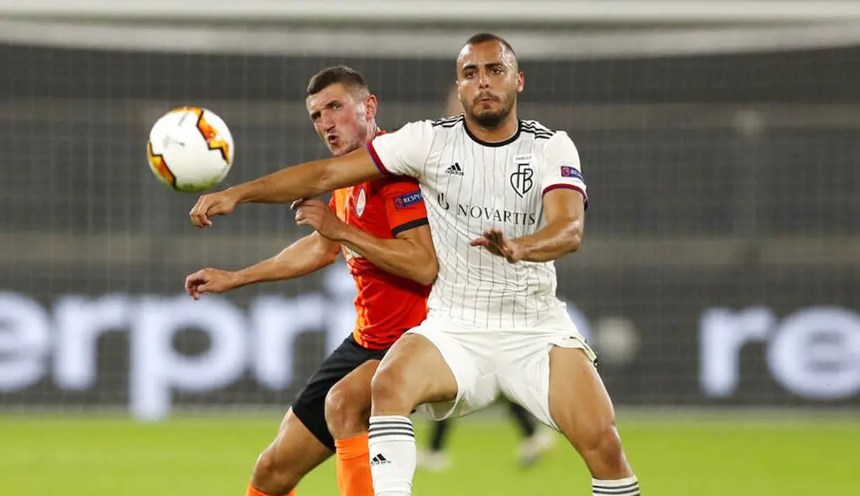Pemain FC Shakhtar Donetsk, Serhiy Kryvtsov, berebut bola dengan pemain FC Basel, Arthur Cabral, pada perempat final di Veltins Arena, Selasa (11/8/2020). Shakhtar Donetsk menang dengan skor 4-1. (Lars Baron/Pool via AP)