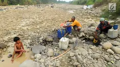 Warga mengambil air pada lubang di aliran Sungai Cipamingkis yang kering, Cibarusah, Bekasi, Jabar, Kamis (2/8). Dua bulan tak diguyur hujan menyebabkan warga perbatasan Bogor-Bekasi dilanda kekeringan dan kesulitan air bersih. (Merdeka.com/Arie Basuki)