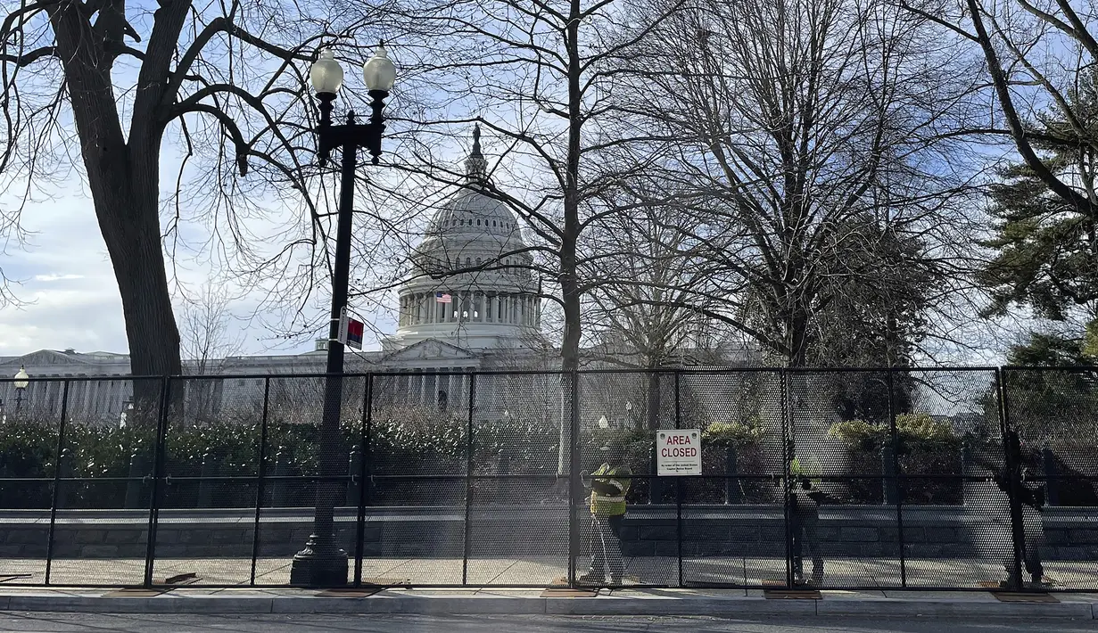 Gedung Capitol AS terlihat di belakang pagar keamanan di Capitol Hill di Washington, Minggu (5/2/2023). Polisi Capitol AS meningkatkan keamanan untuk pidato kenegaraan Presiden Joe Biden di Kongres pada Selasa (7/3) malam waktu AS, termasuk menambahkan pagar yang tidak dapat diskalakan di sekitar halaman Capitol, menurut dua sumber yang mengetahui rencana tersebut. (AP Photo/Anna Johnson)