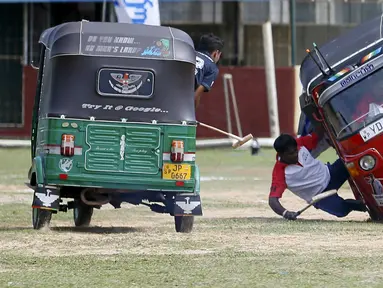 Dua peserta berebut bola saat mengikuti kompetisi "Tuk Tuk Polo" di Galle, Sri Lanka, (21/2). Tuk Tuk merupakan kendaraan roda tiga atau bisasa dikenal Bajaj yang menjadi alat transportasi warga Sri Lanka. (REUTERS/Dinuka Liyanawatte)