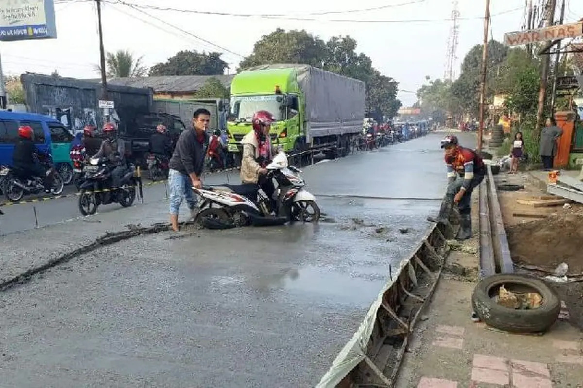 Emak-emak terperosok di jalan basah setelah dicor (Istimewa)