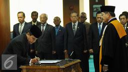 Mirza Adityaswara (kiri) menandatangani nota pelantikan sebagai Anggota Dewan Komisioner OJK di Sekretariat MA, Jakarta, Kamis (20/8/2015). Mirza diangkat berdasar SK Presiden No 61/P/2015 tanggal 23 Juli2015 . (Liputan6.com/HelmiFithriansyah)