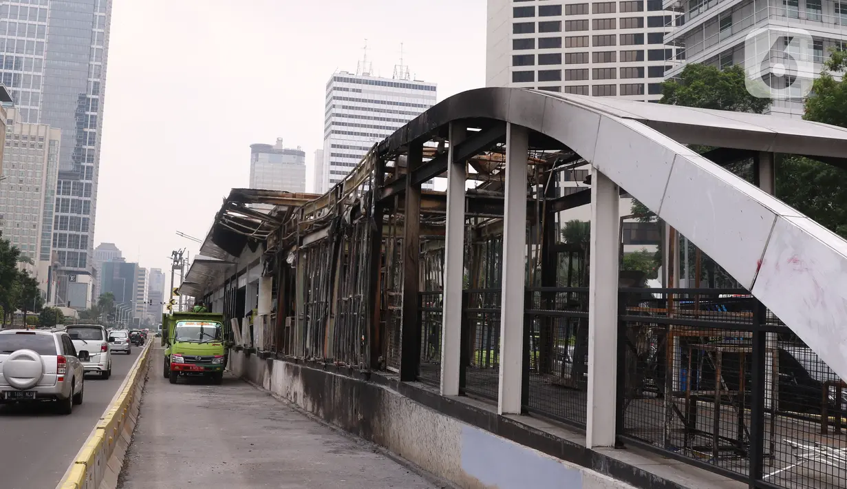Kendaraan melintas di dekat halte transjakarta Tosari yang dibakar massa perusuh di Jakarta, Jumat (9/10/2020). Demo menolak omnibus law Undang-Undang (UU) Cipta Kerja diwarnai kericuhan dan pembakaran terhadap sejumlah halte Transjakarta. (Liputan6.com/Angga Yuniar)