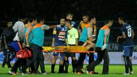 Gelandang Bhayangkara FC, TM Ichsan, harus ditandu keluar lapangan dalam pertandingan kontra Arema FC di laga pamungkas Grup E Piala Presiden 2018 yang digelar di Stadion Kanjuruhan, Malang, Selasa (9/1/2018). (Bola.com/Iwan Setiawan)