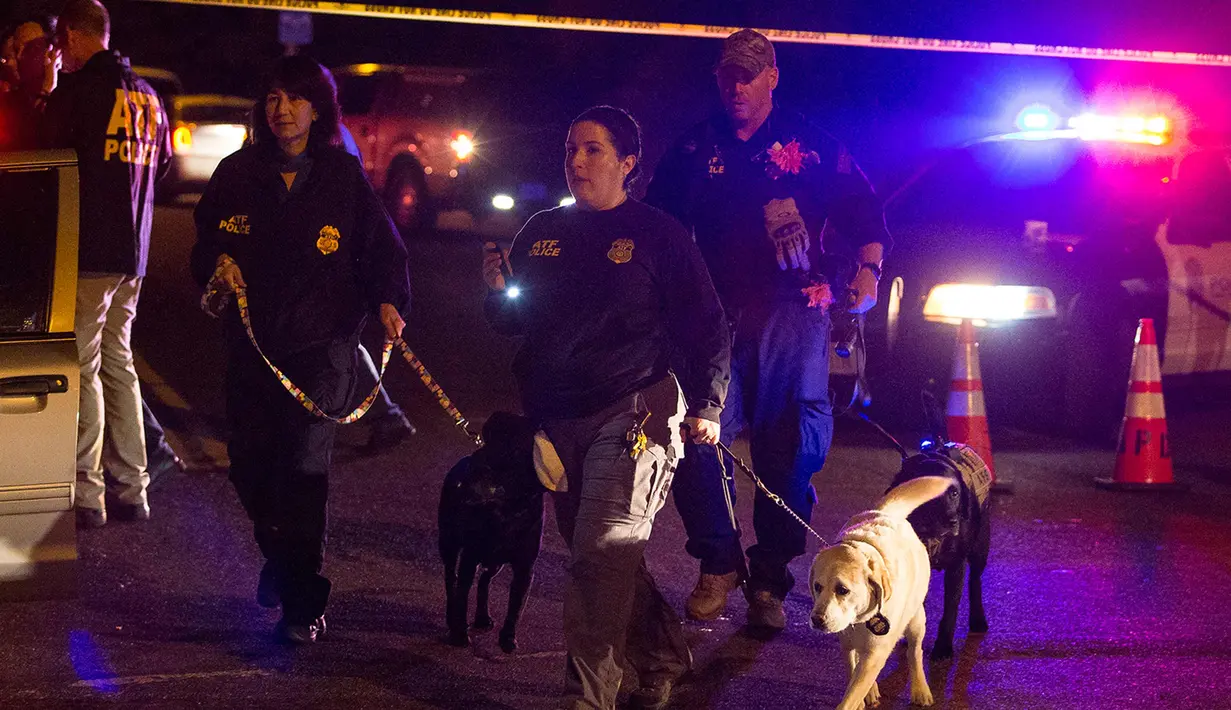 Polisi membawa anjing pelacak di lokasi ledakan di Austin, Texas (18/3). Area di sekitar lokasi ledakan telah diblokir dan otoritas mewawancarai tetangga dan mencari saksi. (Nick Wagner / Austin American-Statesman via AP)
