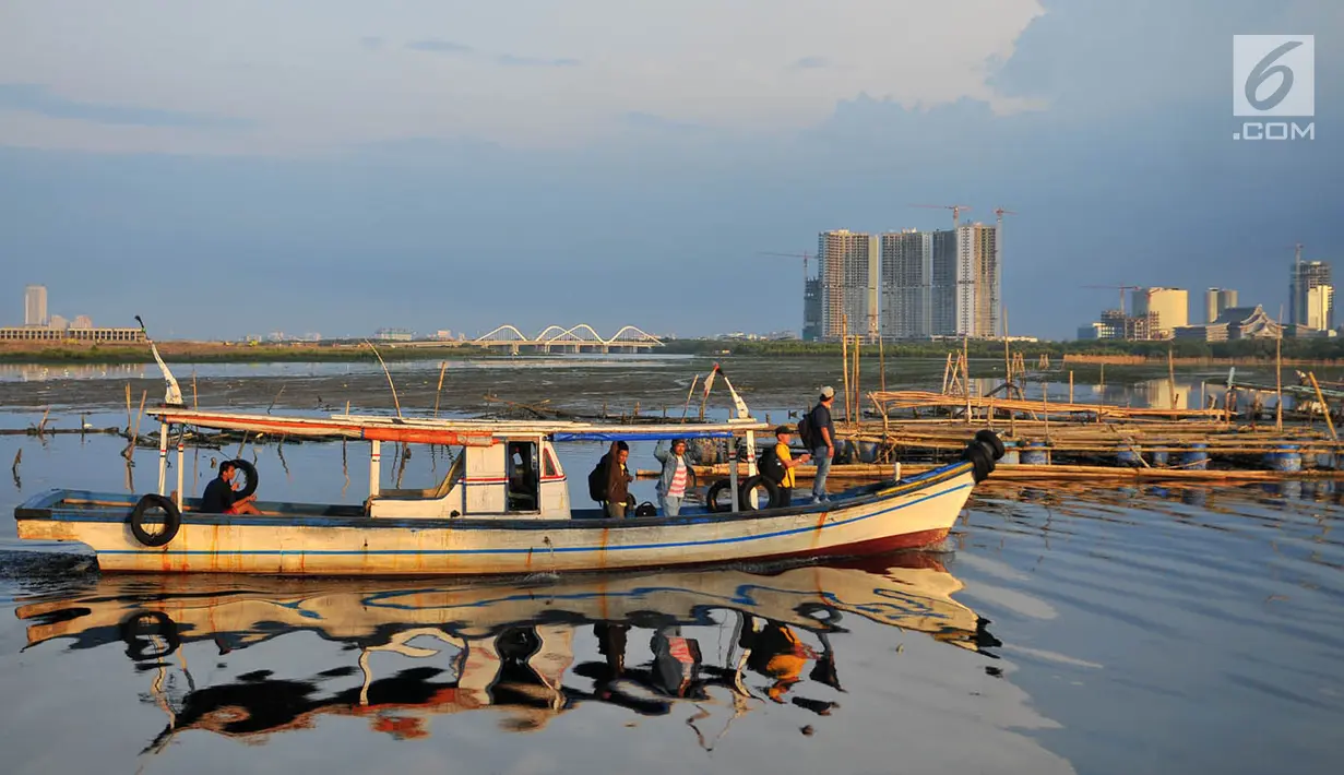 Nelayan melintasi area permukaan air laut yang menyurut di sekitar pesisir Kamal Muara, Jakarta, Kamis (15/3). Sebelum ada reklamasi, menurut warga setempat permukaan air laut tetap stabil meski tidak pasang. (Merdeka.com/Iqbal S Nugroho)