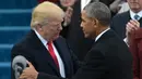 Barack Obama menyalami Donald Trump jelang penyampaian pidato pertama Trump sebagai Presiden AS di Capitol Hill, Washington DC, AS, Jumat (20/1). Dikabarkan, Trump sendiri yang menulis dan menyusun pidato pelantikannya. (AFP Photo)