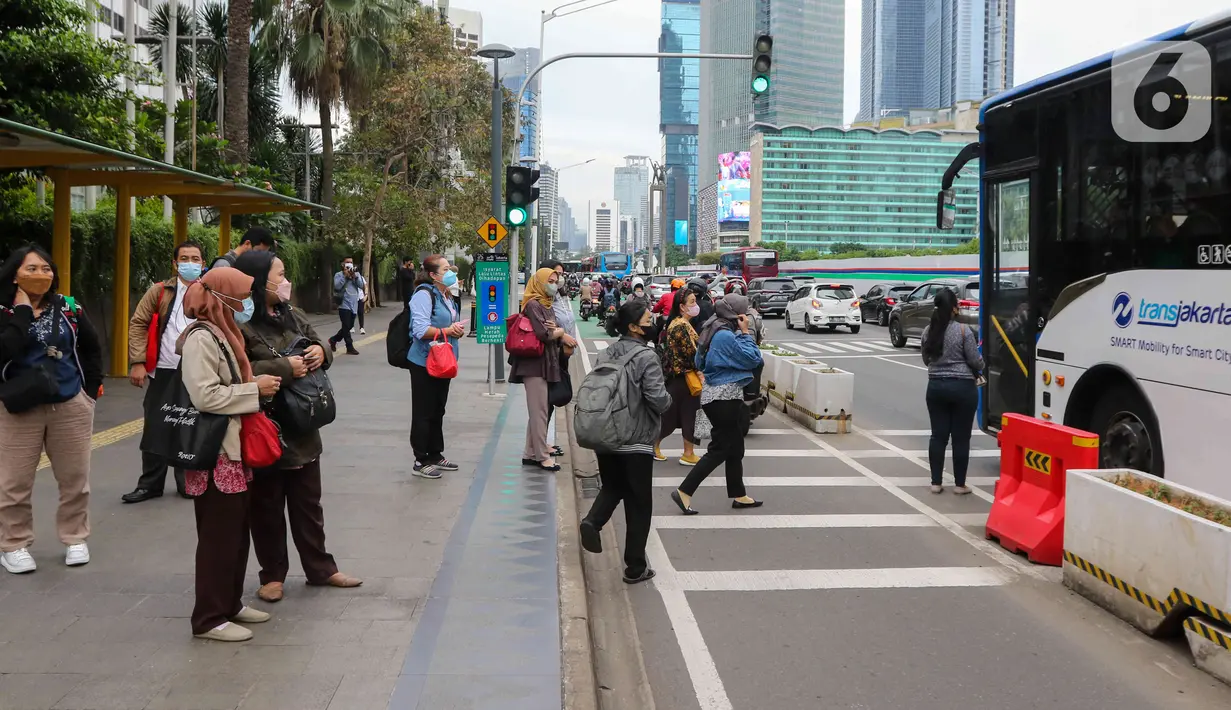 Pekerja sedang menunggu transportasi umum di kawasan Jalan Mh Thamrin, Jakarta, Rabu (25/5/2022). Kawasan Jabodetabek memberlakukan PPKM Level 1 mulai 24 Mei selama dua pekan mendatang. Selama kebijakan berlaku, karyawan di perusahaan sektor non esensial diperbolehkan bekerja dari kantor atau work from office (WFO) dengan kapasitas 100 persen. (Liputan6.com/Herman Zakharia)