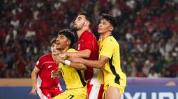 Jens Raven (tengan) tampak dijaga ketat oleh dua pemain Malaysia  pada laga pemungkas Grup A Piala AFF U-23 2025, Senin (21/7/2025). (Bola.com/Abdul Aziz)