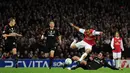 Pemain Arsenal, Theo Walcott menghindari tekel pemain AC Milan pada laga Liga Champions di Stadion Emirates, Selasa (6/3/2015). Kecepatan Walcott kerap merepotkan barisan pertahanan lawan. (AFP Photo/Adrian Dennis)