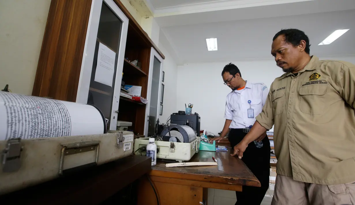 Petugas memantau aktivitas Gunung Anak Krakatau lewat seismograf di sebuah pos pengamatan di Carita, Banten, Kamis (27/12). Naiknya status Gunung Anak Krakatau membuat radius bahaya diperluas menjadi 5 kilometer. (AP Photo/Achmad Ibrahim)