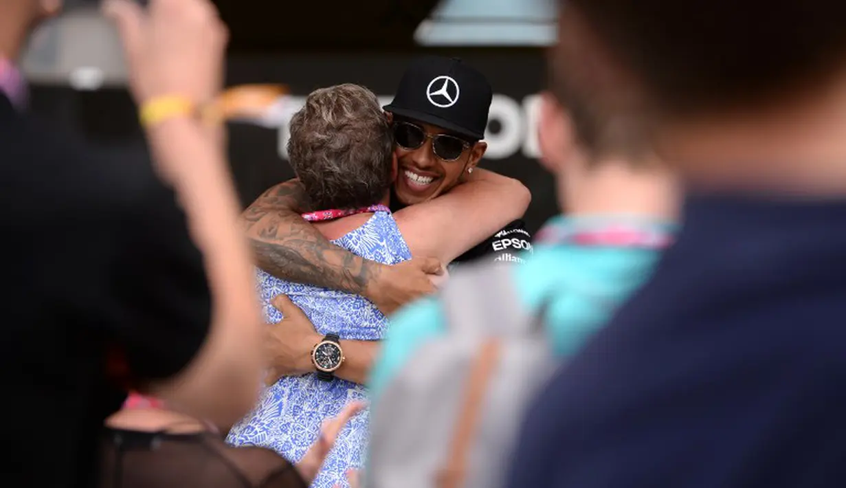 Pebalap Tim Mercedes AMG Petronas F1, Lewis Hamilton, memeluk ibunya setelah memenangi F1 GP Inggris di Sirkuit Silverstone, Inggris. (5/7/2015). (AFP PHOTO/OLI SCARFF)