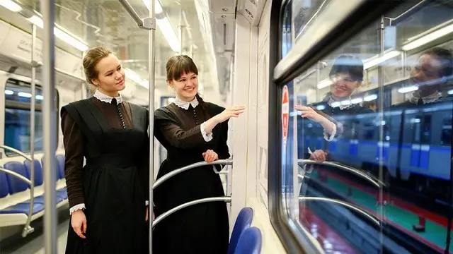 Dua orang perempuan mengenakan seragam siswa zaman dulu di Plekhanovets, kereta bawah tanah terbaru Moskow dalam rangka ulang tahun ke-110 Universitas Ekonomi Rusia Plekhanov. Sumber: Kantor Pers Metro Moskow/TASS