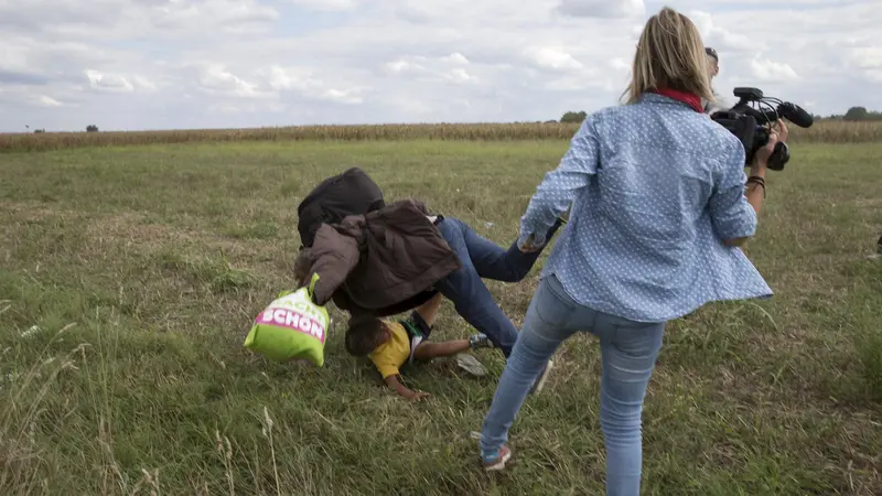 Juru kamera perempuan dari stasiun televisi Hungaria, N1TV menendang pengungsi Suriah